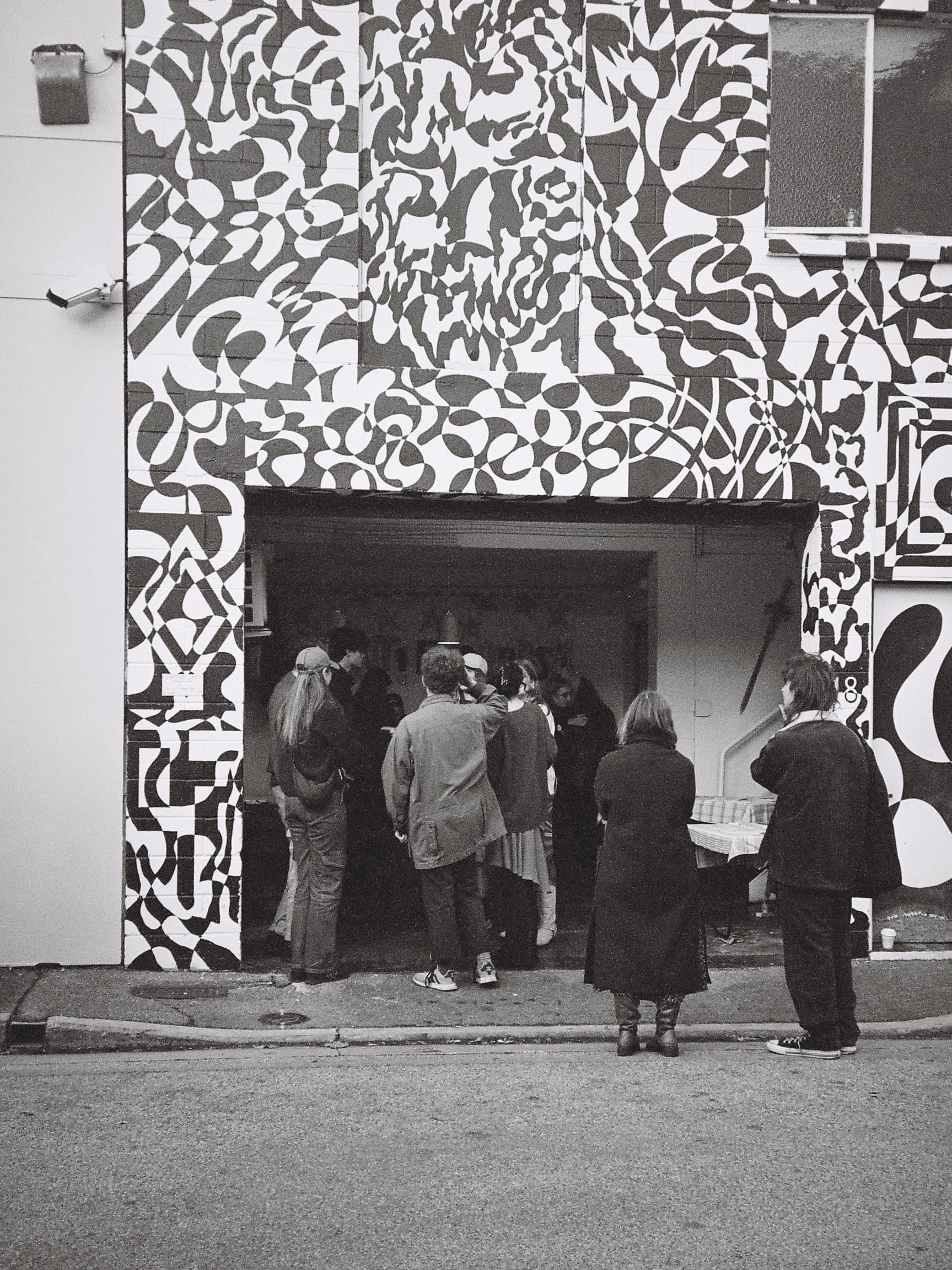 People gathered at the patterned laneway entrance to the studio
