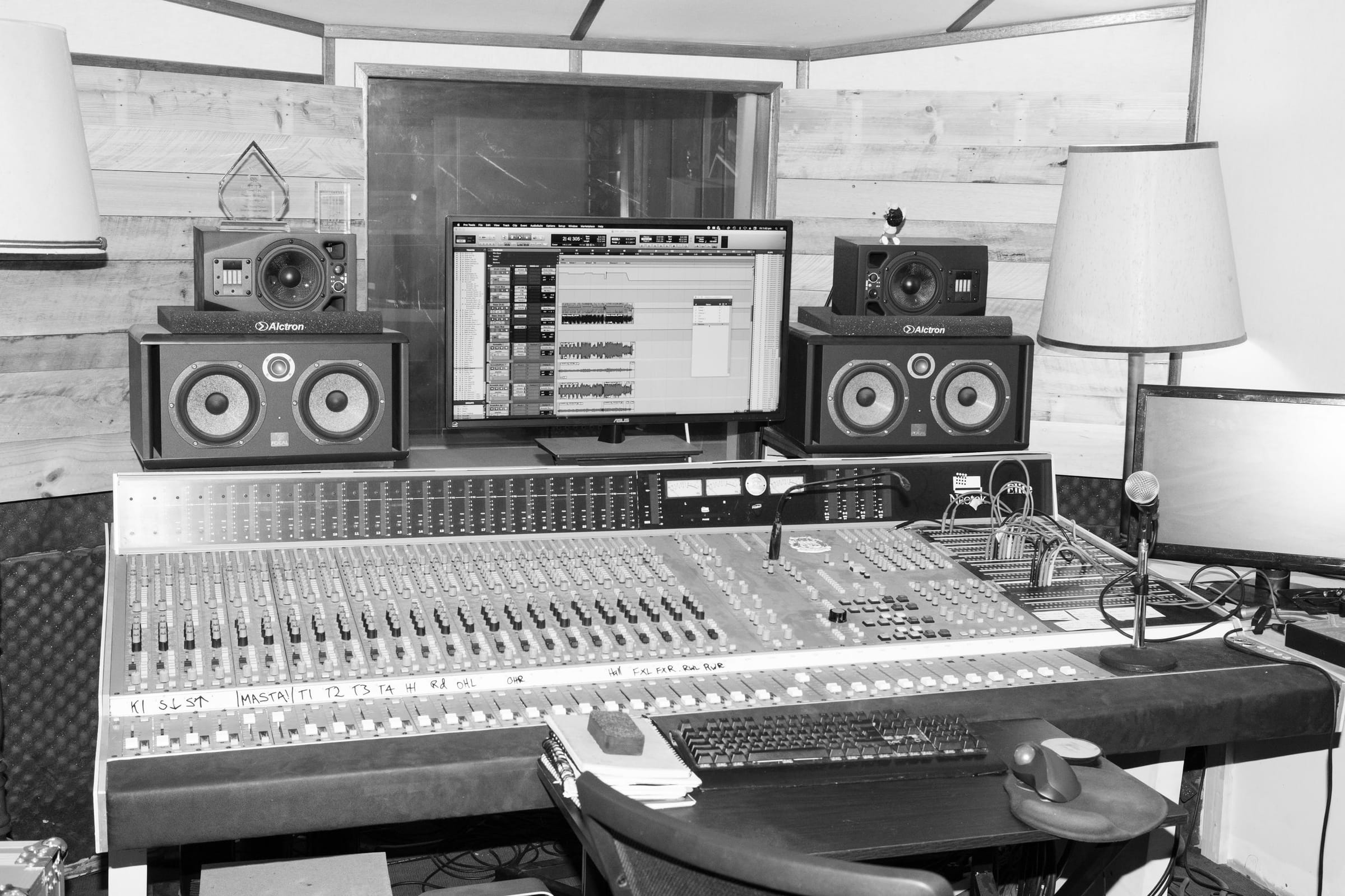 The analogue mixing console and monitors in the control room