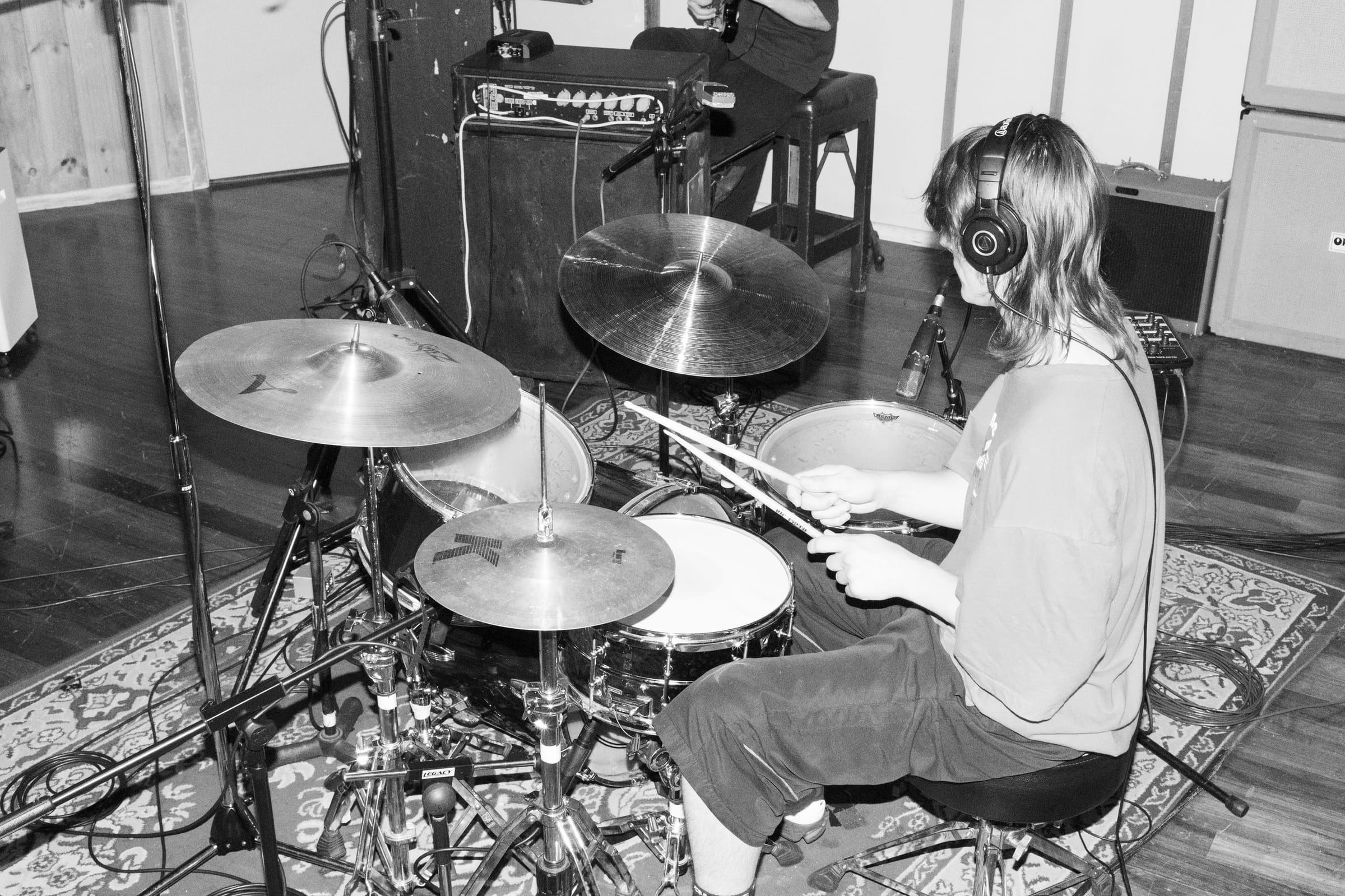 A drummer recording in the live room surrounded by microphones
