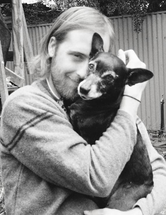 Tom Matheson holding a small black dog